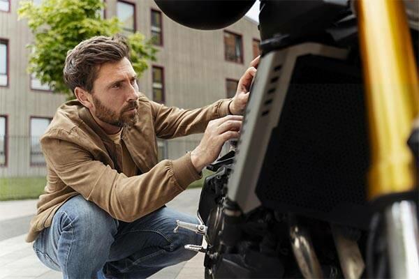 homem consertando a sua moto