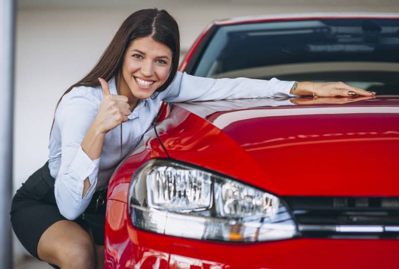 Foto de uma mulher junto a um carro